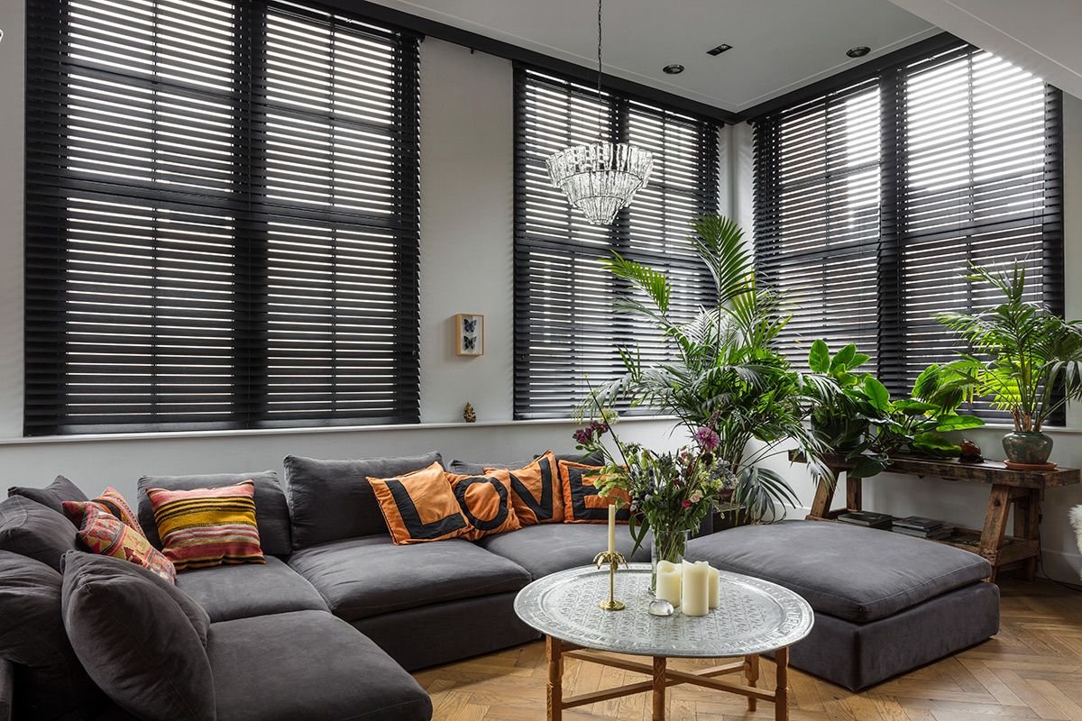 Dark plantation shutters fitted on large floor-to-ceiling windows